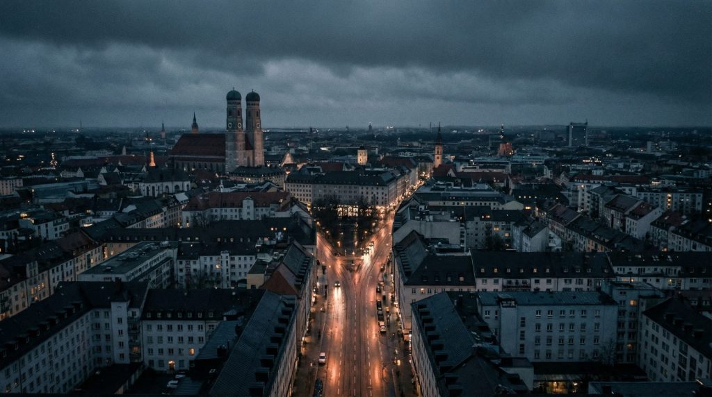 Die nächtliche Stadtlandschaft symbolisiert die Anonymität und das Gefühl des Verlorenseins in der großen, komplexen juristischen Welt einer Großstadt wie München – passend zur Verortung des Artikels.